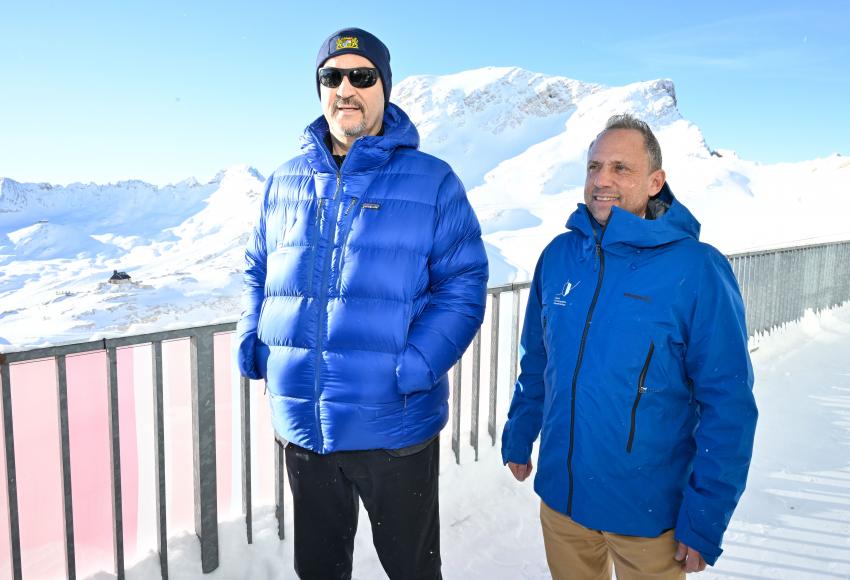 Bayerns Ministerpräsident Dr. Markus Söder (li.) und Umweltminister Thorsten Glauber stehen zusammen am Schneefernerhaus, im Hintergrund schneebedeckte Berge.