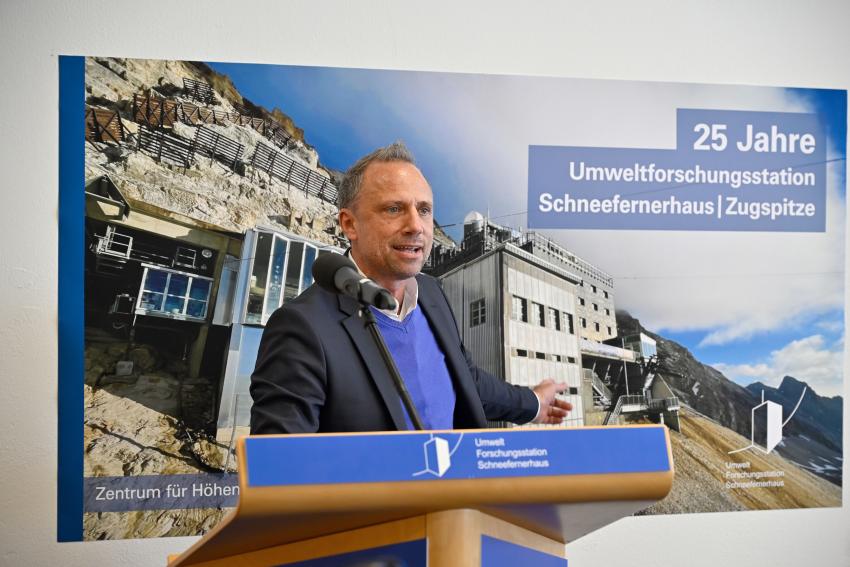 Am Rednerpult steht Umweltminister Thorsten Glauber und hält eine Rede zu 25 Jahre Umweltforschungsstation Schneefernerhaus.