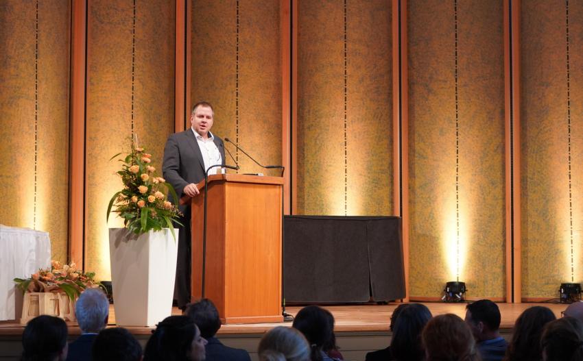 Herr Prof. Christian Weidner (LGL-Präsident Bayern) steht als Ehrengast am Rednerpult und spricht ein Grußwort.