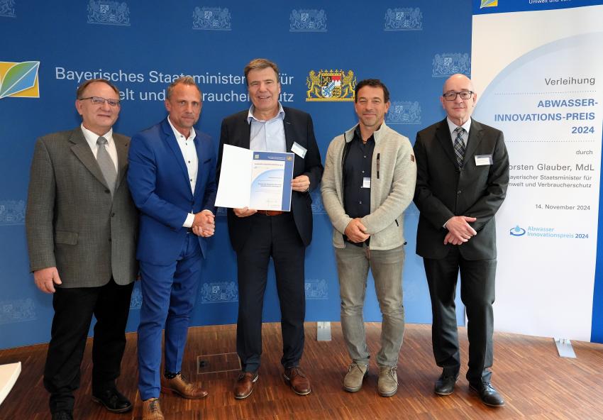 Die Gemeinde Karlsfeld erhält den Prämienpreis für das Projekt „Neubau Faulbehälter 2 zur Erhöhung der Gasausbeute“. Das Gruppenfoto zeigt Umweltminister Thorsten Glauber und Vertreter der Gemeinde Karlsfeld, Stefan Kolbe (1. Bürgermeister Gemeinde Karlsfeld) mit der Auszeichnungsurkunde.