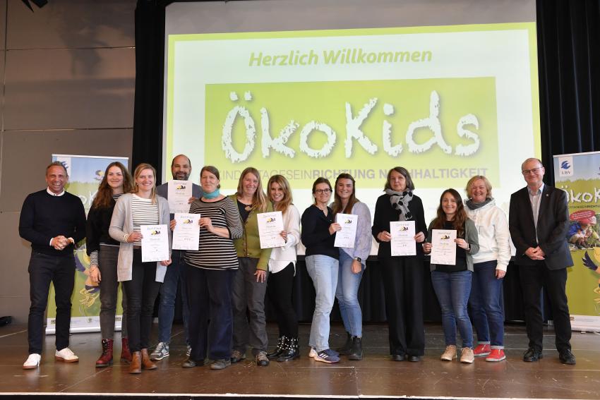 Gruppenfoto zeigt Umweltminister Thorsten Glauber (Foto links), die Vertreterinnen und Vertreter der ausgezeichneten Kindertageseinrichtungen und Dr. Norbert Schäffer, 1. Vorsitzender LBV (Foto rechts).