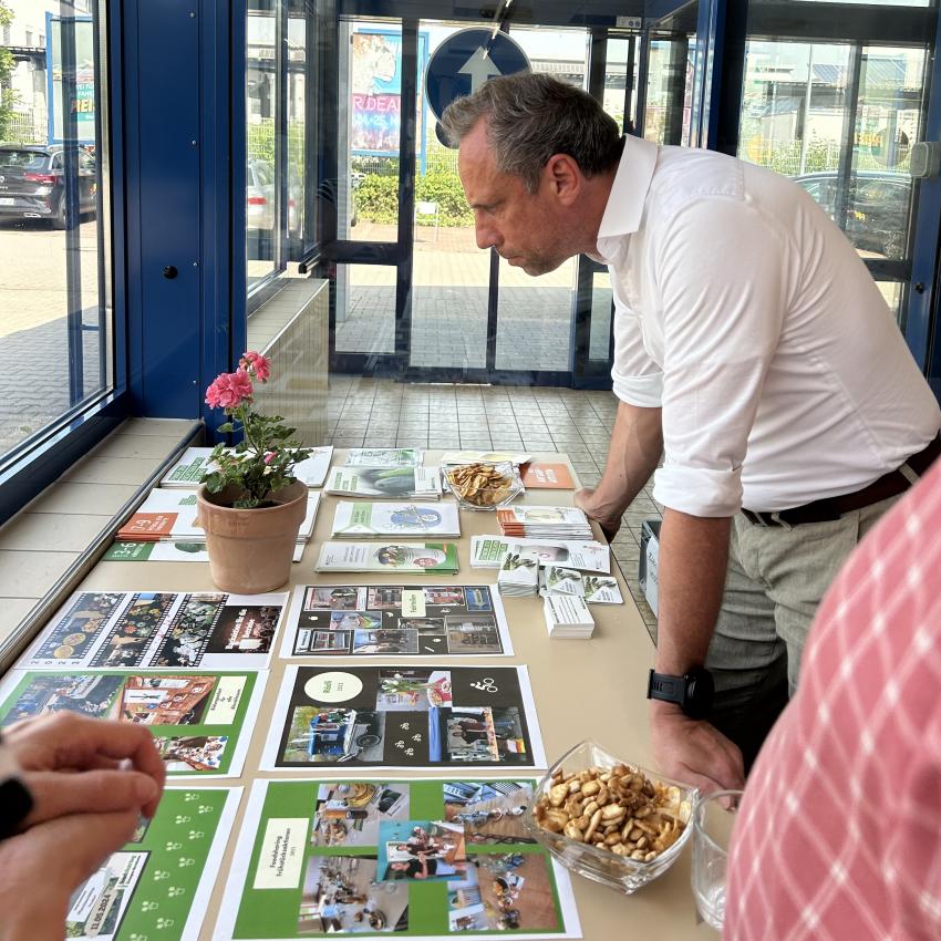 Umweltminister Thorsten Glauber schaut sich Bilder der unterschiedlichen Aktionen des Kreislaufkaufhauses Forchheim an