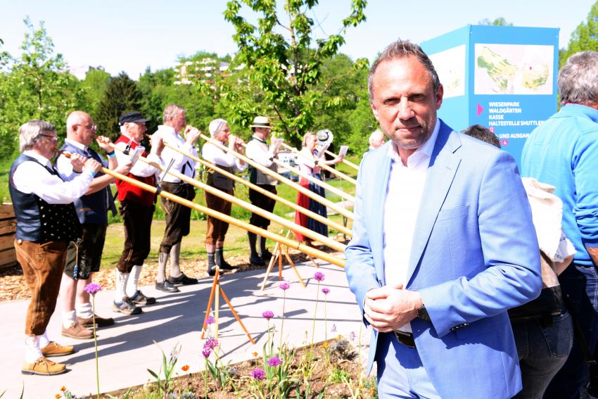 Umweltminister Thorsten Glauber, im Hintergrund spielen die Alphornbläser 