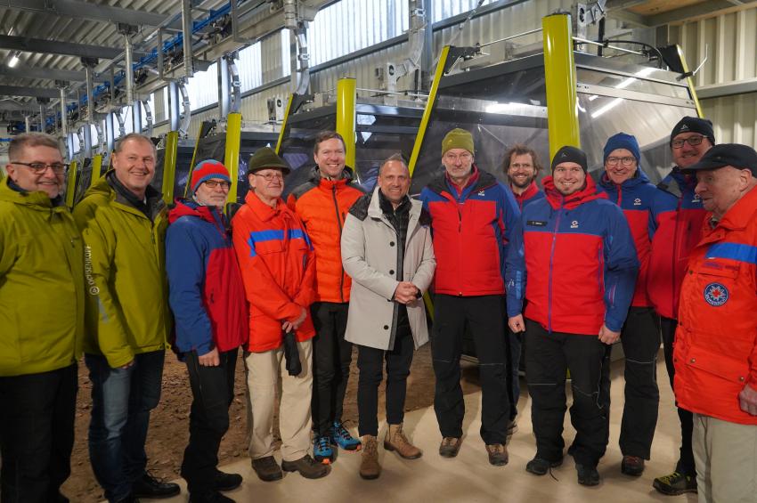 Gruppenfoto zur feierlichen Eröffnung der neuen Seilbahnen am Ochsenkopf zeigt Umweltminister Thorsten Glauber (Mitte), Landrat des Landkreises Bayreuth Florian Wiedemann (links hinter Umweltminister Thorsten Glauber), Mitarbeiter der Seilbahnen Ochsenkopf und der Bergwacht.