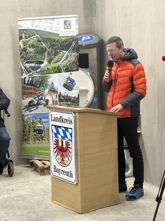 Am Rednerpult steht Landrat des Landkreises Bayreuth Florian Wiedemann und hält eine Rede.