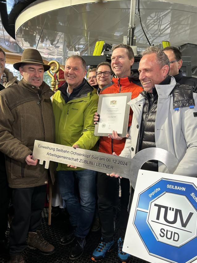 Das Gruppenfoto zeigt Wirtschaftsminister Hubert Aiwanger (li.), Bürgermeister von Warmensteinach Axel Herrmann und Umweltminister Thorsten Glauber, zusammen halten  sie den symbolischen Schlüssel für die Eröffnung der Seilbahn Ochsenkopf Süd.  Landrat des Landkreises Bayreuth Florian Wiedemann (2. v. re.) hält die Urkunde in den Händen.