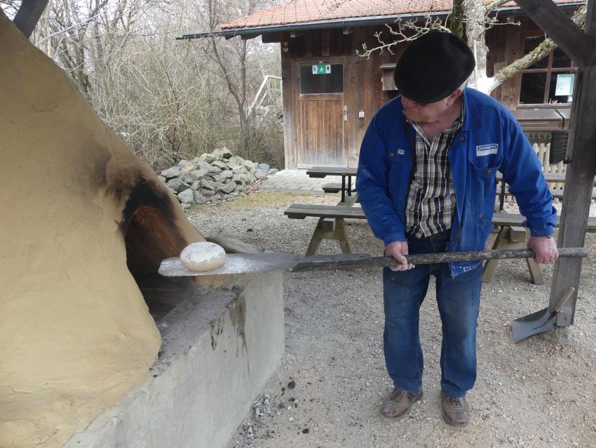 Walter Gründl schießt Brot in den Holzbackofen