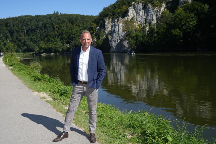 Bayerische Umweltminister Thorsten Glauber steht am  Donauufer.