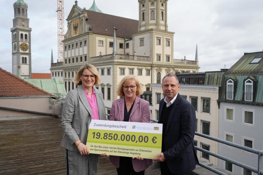 Umweltminister Thorsten Glauber übergibt den Zuwendungsscheck an die Stadt Augsburg für den Bau einer 4. Reinigungsstufe im Klärwerk Augsburg. Das Foto zeigt von li. n. re.: Oberbürgermeisterin Stadt Augsburg Eva Weber, Leiterin des WWA in Donauwörth Gudrun Seidel und Umweltminister Thorsten Glauber.