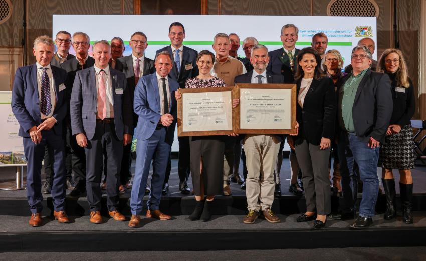 Umweltminister Thorsten Glauber verleiht die IUCN-Zertifikate (Internationale Union zum Schutz der Natur) an die Nationalparke Bayerischer Wald und Berchtesgaden. Die Nationalparks erfüllen damit den hohen Qualitätsstandard für verschiedene Kategorien von Schutzgebieten weltweit. Gruppenfoto, 1. Reihe v. li. n. re.: Peter Südbeck (Vorstandsvorsitzender bei Nationale Naturlandschaften e. V.), Helmut Plenk (stv. Landrat Landkreis Regen), Thorsten Glauber (Bayerische Staatsminister für Umwelt und Verbraucherschutz), Ursula Schuster (Leiterin des Nationalparks Bayerischer Wald), Dr. Roland Baier (Leiter des Nationalparks Berchtesgaden), Michaela Kaniber (Bayerische Staatsministerin für Ernährung, Landwirtschaft, Forsten), Dr. Eick von Ruschkowski (Vertreter der IUCN)