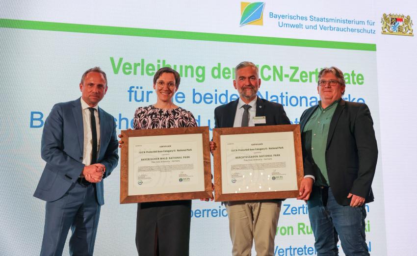 Das Foto zeigt von links: Umweltminister Thorsten Glauber, Naturparkleiterin Bayerischer Wald Ursula Schuster und Leiter des Nationalparks Berchtesgaden Dr. Roland Baier halten jeweils ihr IUCN-Zertifikat in den Händen, Dr. Eick von Ruschkowski, Vertreter der IUCN.