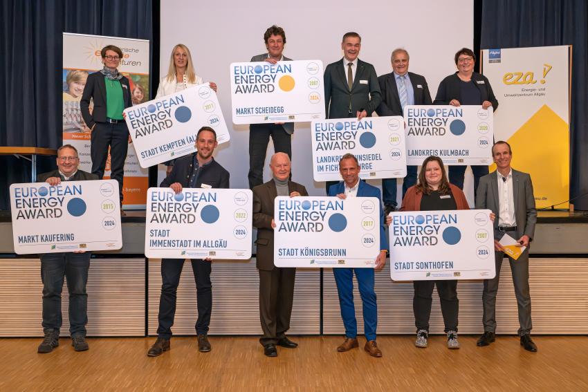 Gruppenfoto mit Umweltminister Thorsten Glauber (1. Reihe, 3. re.) zusammen mit den Preisträgerinnen und Preisträgern der Kommunen und Landkreise, Martin Sambale (Geschäftsführer der eza!, Berater für Immenstadt und Moderator der Veranstaltung; 1. Reihe re.) Foto: eza!/Thomas Gretler