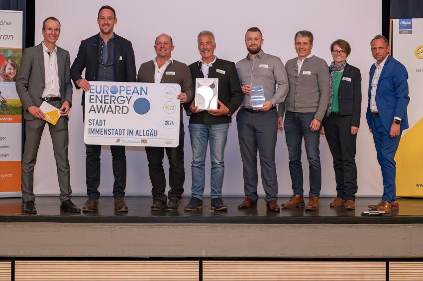 Das Gruppenfoto zeigt Umweltminister Thorsten Glauber (re.), Martin Sambale (Geschäftsführer der Energie- und Umweltzentrum Allgäu (eza!), Berater für Immenstadt und Moderator der Veranstaltung, li.) und die Preisträgerinnen und Preisträger der Stadt Immenstadt (Lkr. Oberallgäu). Foto: eza!/Thomas Gretler