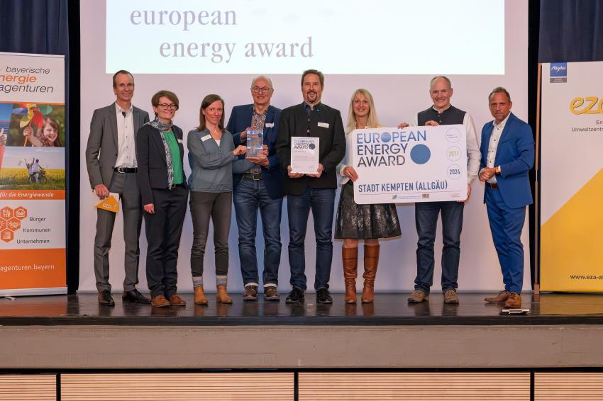 Das Gruppenfoto zeigt Umweltminister Thorsten Glauber (re.), die Preisträgerinnen und Preisträger der Stadt Kempten (Lkr. Oberallgäu) und links im Bild Martin Sambale (Geschäftsführer der eza!, Berater für Immenstadt und Moderator der Veranstaltung). Foto: eza!/Thomas Gretler