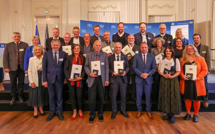 Das Gruppenfoto zeigt Umweltminister Thorsten und den Geehrten mit Begleitpersonen.