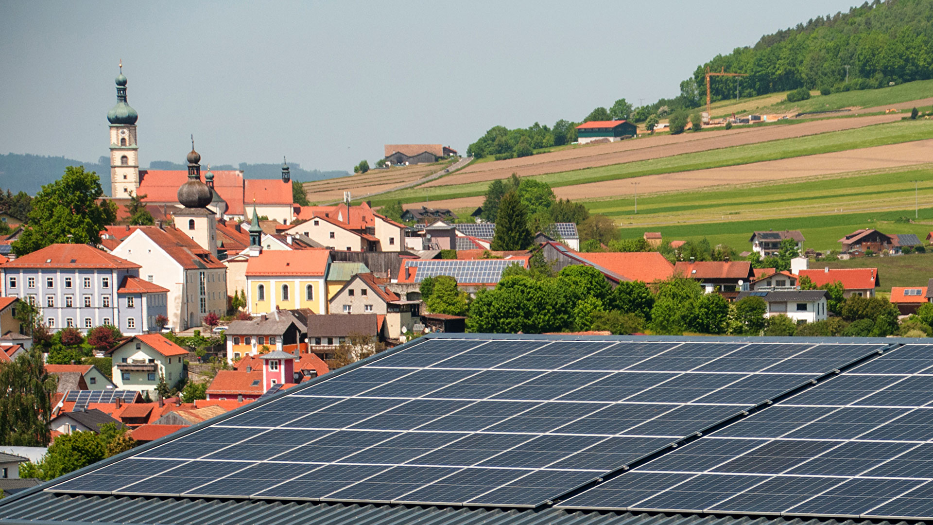 Panoramabild von einer bayerischen Gemeinde mit Photovoltaik-Anlagen auf vereinzelten Dächern